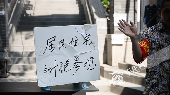 The sign “Residential Building, Visits Prohibited” hung at the entrance of Baixiangju Community on May 24.