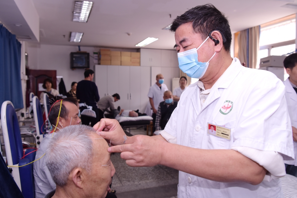 江津区中医院医生正在为基层患者进行针灸治疗