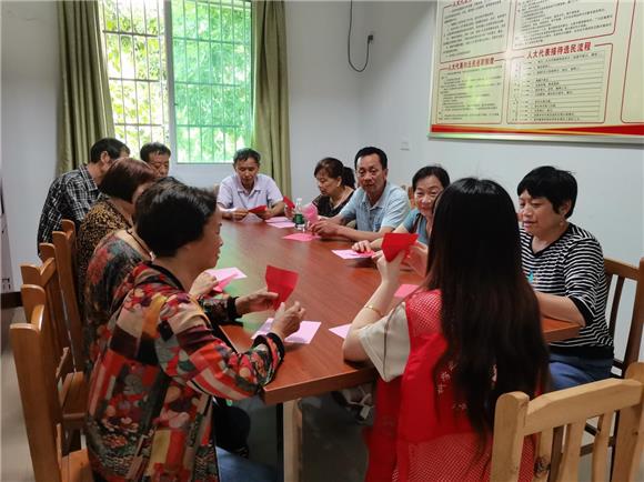 社工对老人进行折纸教学。通讯员 邓甫琼 摄