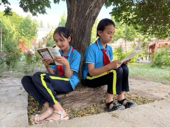 伽师县江巴孜乡第一小学的学生们在室外阅读。通讯员 刘舟 摄