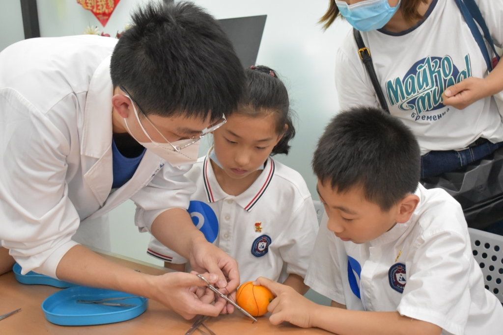 Children from Shapingba Primary School are performing “operations” to oranges with their own hands.