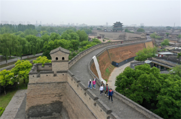 游客在平遥古城城墙上游览（5月30日摄，无人机照片）。新华社记者 詹彦 摄