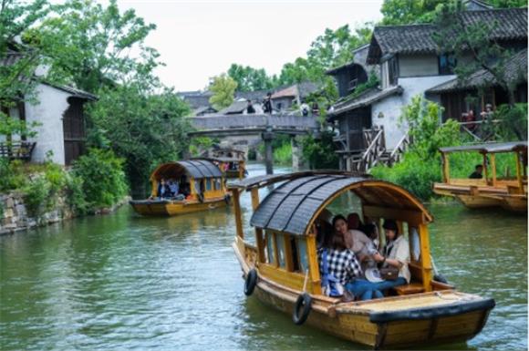  5月2日，游客在濮院时尚古镇内乘船游览。新华社记者 徐昱 摄