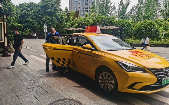 “雷锋的士”驾驶员黄兴平搀扶老人下车。受访者供图