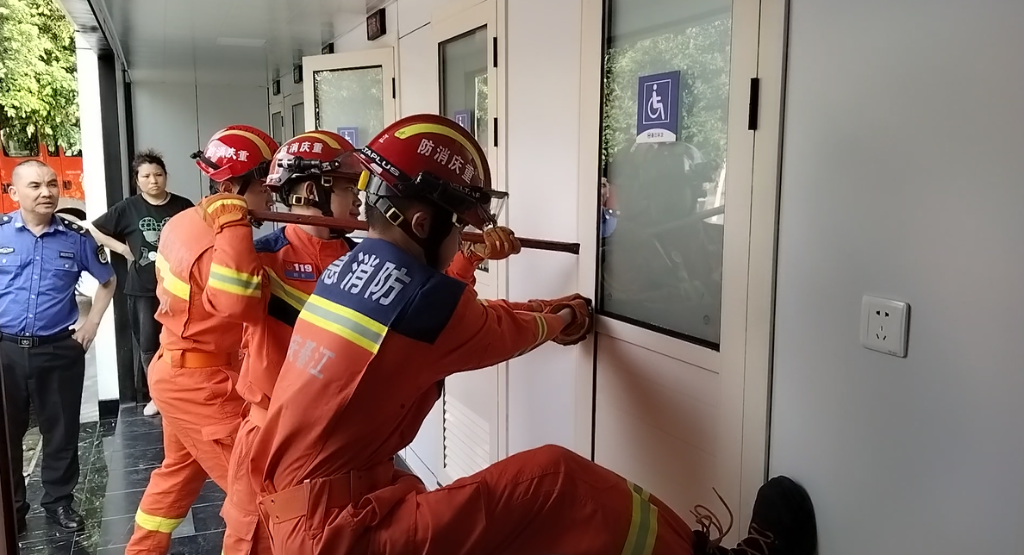1消防员撬门施救。重庆綦江消防供图