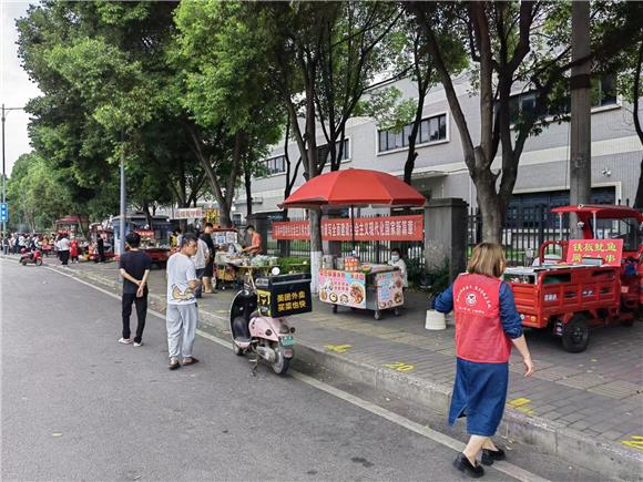 2志愿者巡查流动摊贩点。通讯员 杨菲 摄