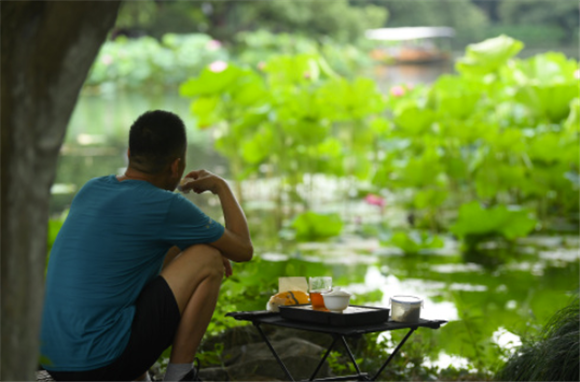 6月11日，游客在曲院风荷景区喝茶赏荷。新华社记者 翁忻旸 摄