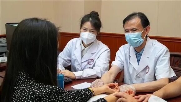 成都中医药大学国医馆名中医梁君昭（右一）正在给患者把脉。梁平区委宣传部供图 华龙网发