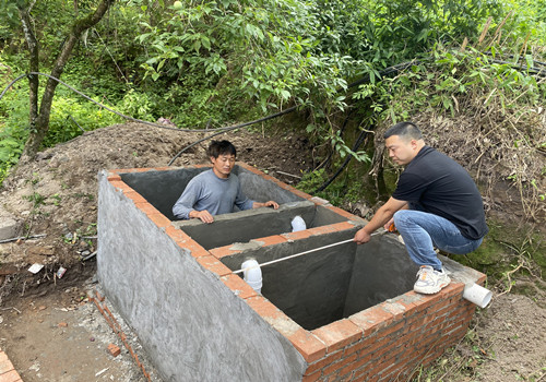 工作人员指导三格式化粪池修建。通讯员 张巧竹 摄
