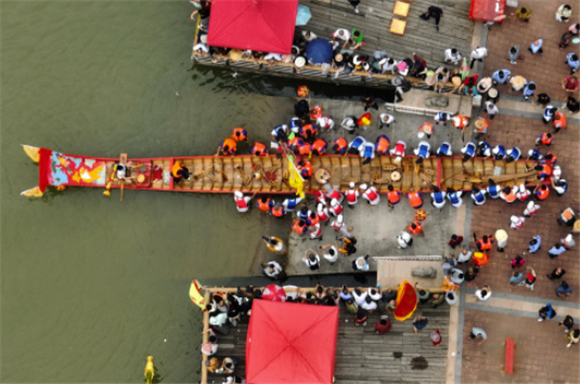 6月13日，在莆田木兰溪畔举行的端午节龙舟传统祭江仪式现场，一艘龙舟下水（无人机照片）。新华社记者 魏培全 摄