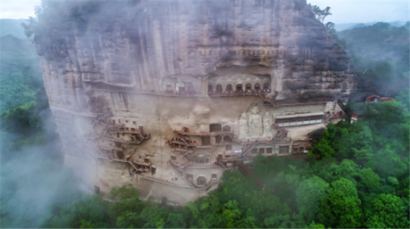 这是5月31日拍摄的烟雨笼罩下的麦积山石窟（无人机照片）。新华社记者 郎兵兵 摄