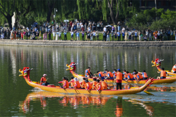 6月22日，游客在北京龙潭湖公园观看龙舟比赛。新华社记者 鞠焕宗 摄