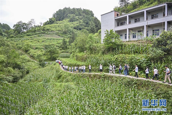 参加再走长征路记者团的记者在位于重庆市綦江石壕镇的当年中央红军走过的长征路上进行体验式采访（7月15日摄）。新华社记者 刘潺 摄