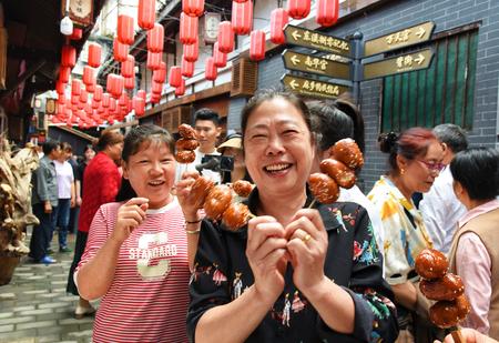 游客买到东溪罗记洗沙油果子非常开心。记者 成蓉 摄