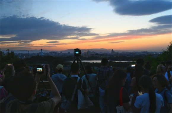 6月7日傍晚，游客在景山上拍摄北海公园。新华社记者 陈晔华 摄
