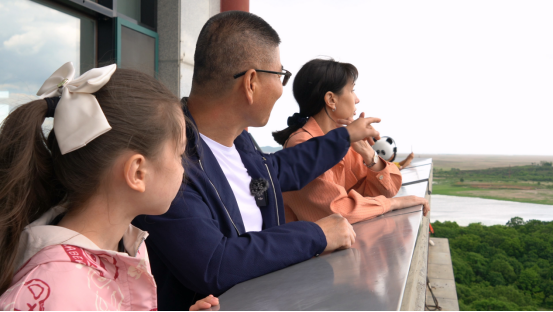 崔媛莹和爸爸妈妈在三国交界处的珲春市防川景区龙虎阁眺望远方。通讯员 李雪筝 摄