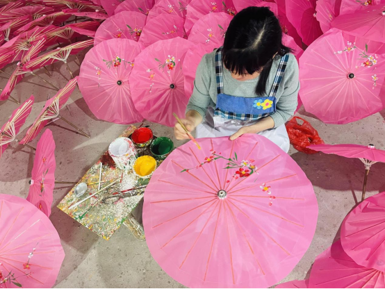 周汉宇将以齐白石为代表的湘潭民间绘画风格移植到石鼓油纸伞的伞面上，完成油纸伞从实用到艺术的功能转型。拼多多供图华龙网发