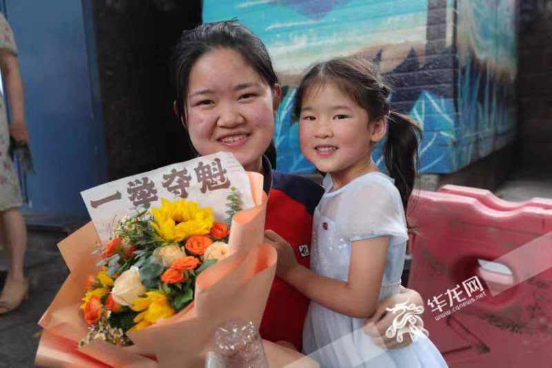 重庆一中考点外，妹妹为姐姐送上鲜花。华龙网-新重庆客户端记者 李文科 石涛 摄