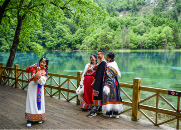 游客身着民族传统服饰在九寨沟景区拍照留念（6月7日摄）。新华社记者 张超群 摄