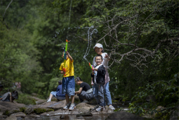 7月8日，家长带着孩子在六盘山国家森林公园玩耍。新华社记者 冯开华 摄