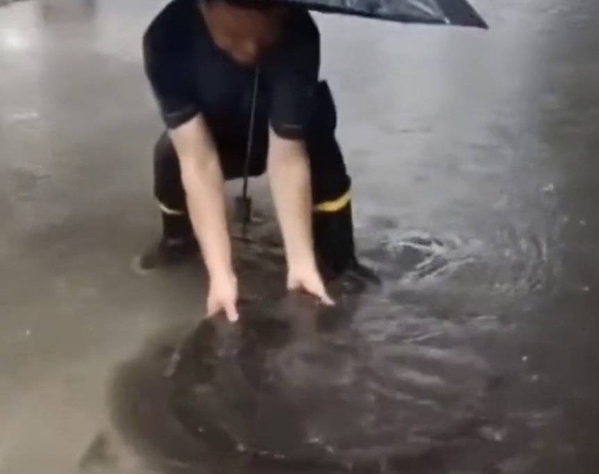 江苏一社区干部雨中徒手扒井盖遭质疑“摆拍”，当地回应：不是摆拍，借助了工具1