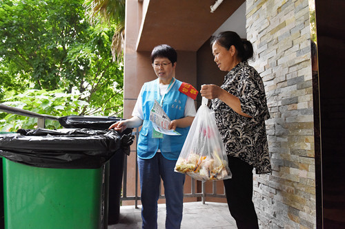 志愿者指导居民正确投放厨余垃圾。特约通讯员 隆太良 摄