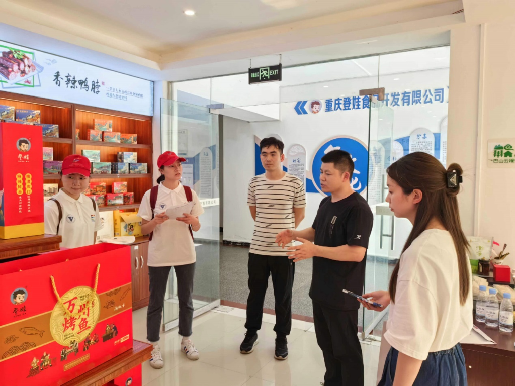 实践团成员们采访重庆登娃食品开发有限公司负责人。