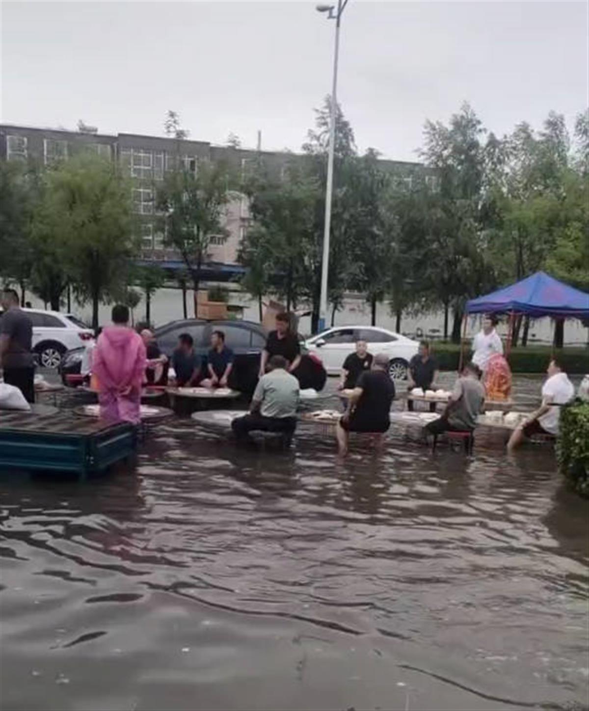 真“流水席”？大雨过后宾客在30厘米深的积水中淡定吃席，只因办白事没法换地方