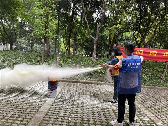 2党员志愿者、居民代表自告奋勇展示如何使用干粉灭火器。通讯员 陈天红 摄
