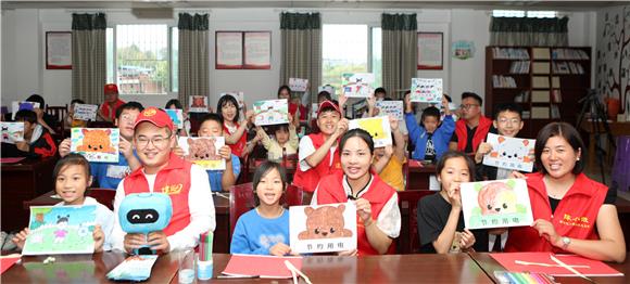 志愿者与孩子展示绘画作品。通讯员 陈仕川 摄