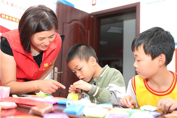志愿者与孩子一起做黏土。通讯员 陈仕川 摄