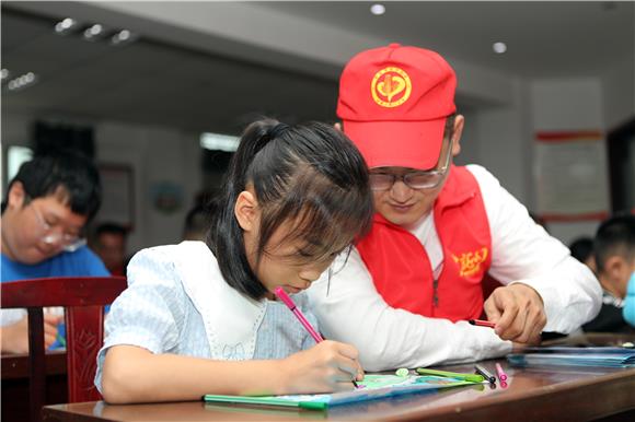 志愿者与孩子一起绘画。通讯员 陈仕川 摄