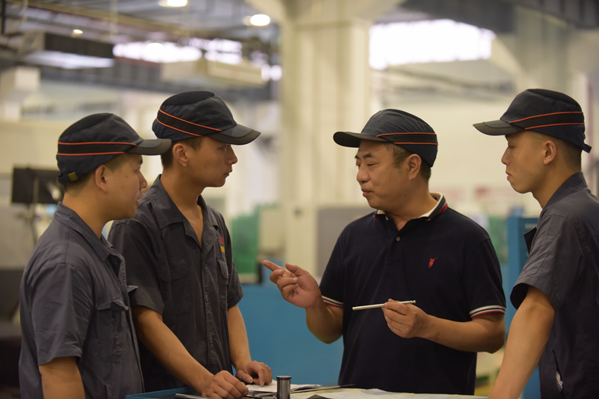 刘平正在向车间里的年轻技工们传授经验。