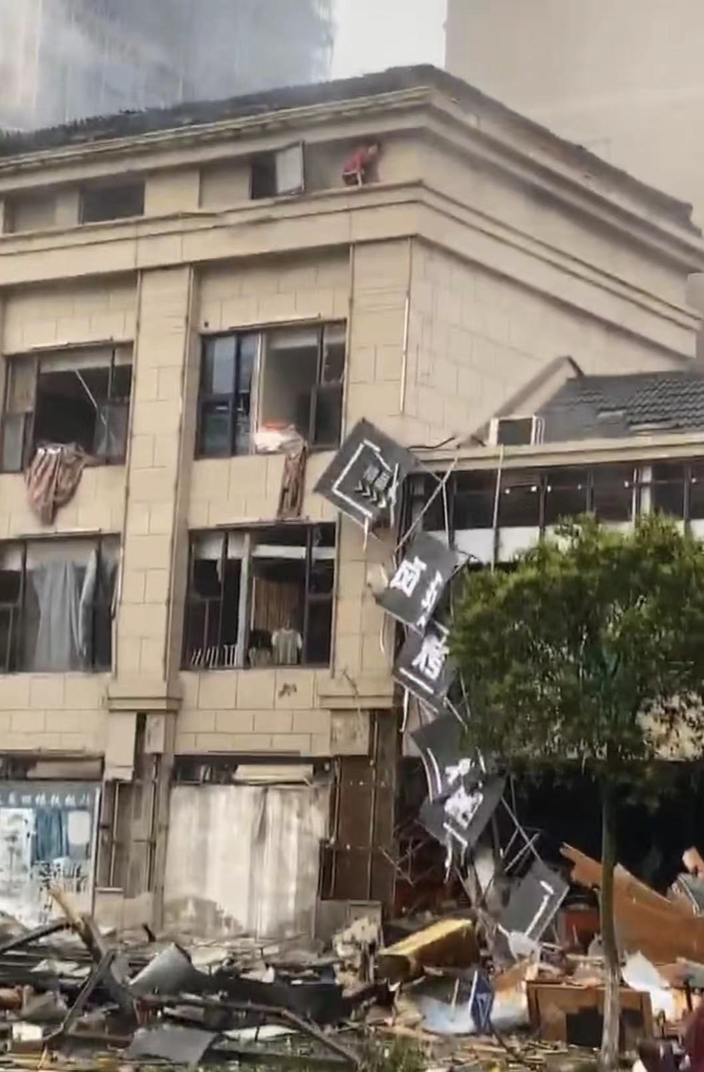 江苏一店铺发生爆炸，现场一片狼藉有人翻窗避险。（视频截图）