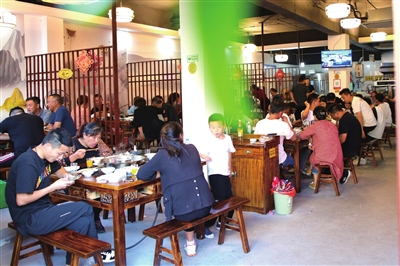 云龙镇龙溪渔街，食客们在店内品尝美味的龙溪鱼。记者 向成国 摄