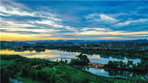 双桂湖国家湿地公园，晚霞倒影在湖面上，与华灯初上的城市形成一幅美丽的风景画。记者 熊伟 摄