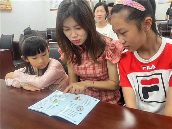 2松石路社区少年儿童家庭正在阅读安全手册。通讯员 唐潇逍 摄