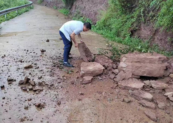 暴雨引起落石，村镇干部正在清理路面障碍。 五桂镇供图 华龙网发
