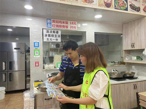 1志愿者与餐饮店老板面对面宣传文明餐桌行动。通讯员 左春燕 摄