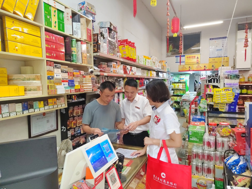 重庆农商行云阳支行水口分理处客户经理肖波（右二）、曾欢（右一）为个体工商户宣传金融政策及产品