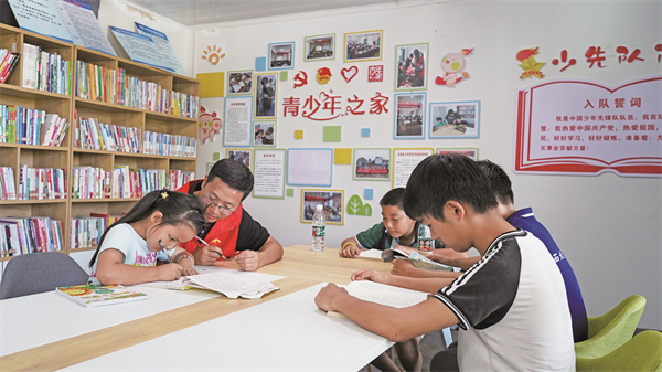 志愿者教孩子画画。记者 邓军杰 供图