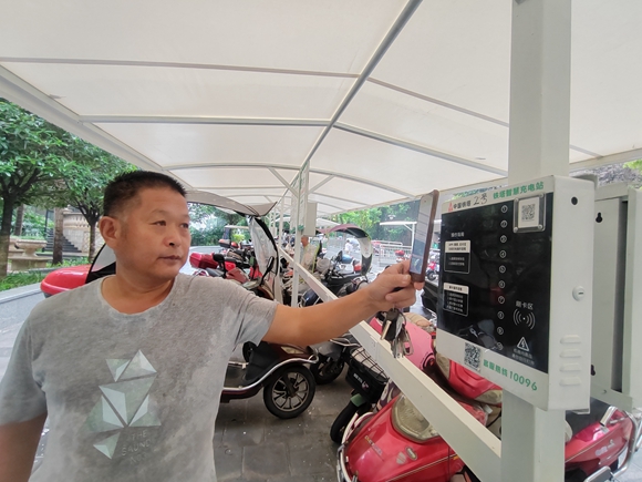 忠县香山湖小区，一名电动车主扫描微信二维码后充电。通讯员 毛世洲 摄