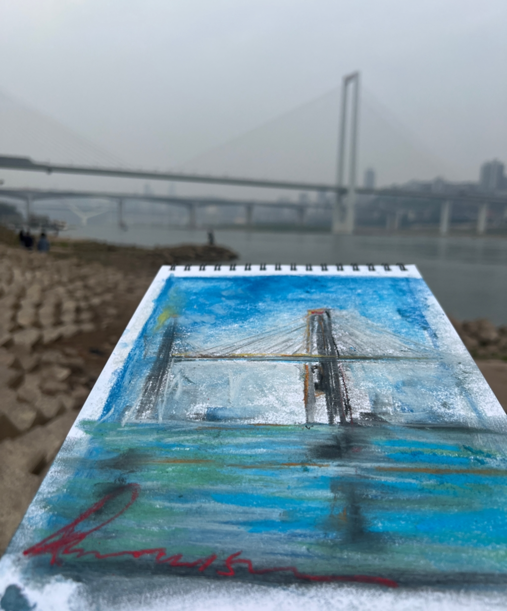 秦海平在重庆江边画大桥。受访者供图