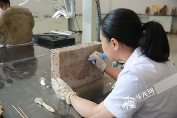 大足石刻文物医院内，工作人员正在清理文物外壁。华龙网-新重庆客户端记者 刘岱松 摄