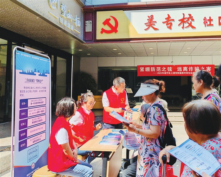 青年志愿者为社区居民发放不动产登记宣传手册、宣讲不动产政策。记者 姚延洋 摄