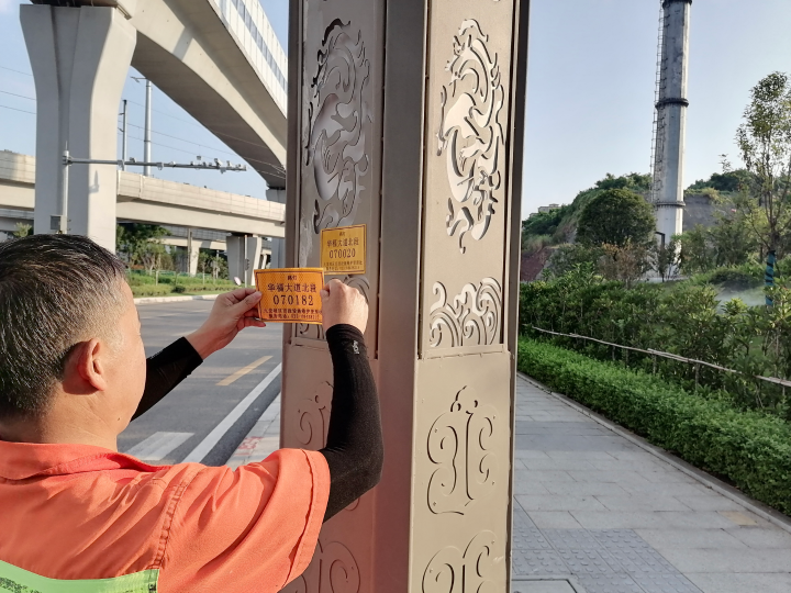 市政工人正在更换路灯铭牌。 九龙坡区城市管理局供图