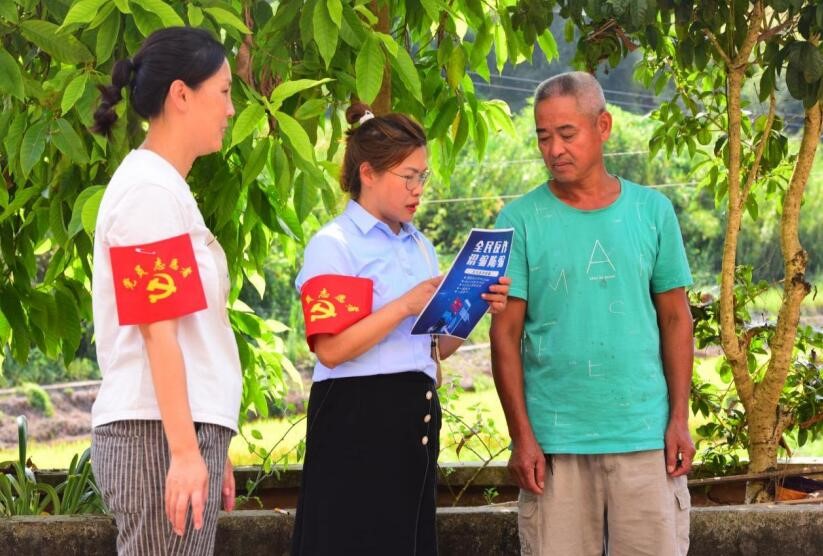 党员志愿者为村民宣传反诈知识。潼南区委宣传部供图  华龙网发