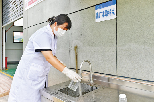 工作人员对出厂水进行取样。记者 崔景印 摄