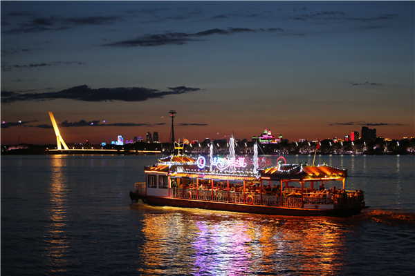 近日，游客乘船在松花江上欣赏哈尔滨的城市景色。新华社记者 石枫 摄