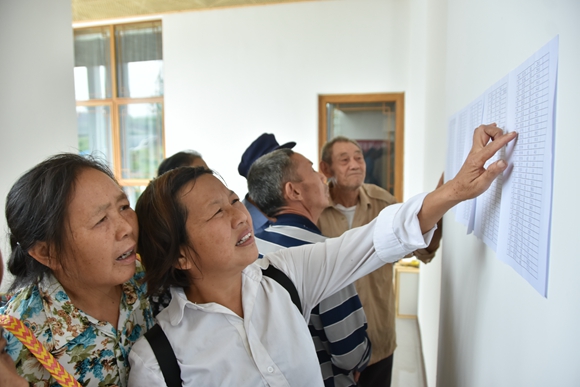 忠县磨子土家族乡竹山村，群众在公示栏查看本户公益积分情况。通讯员 毛世洲 摄